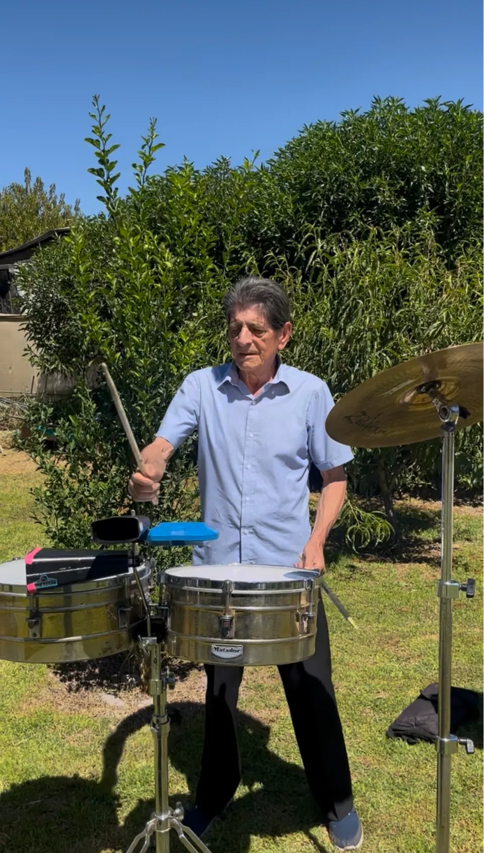 Gustavo “El Papi” Dinamarca tocando los timbales a plena luz del día, en el patio