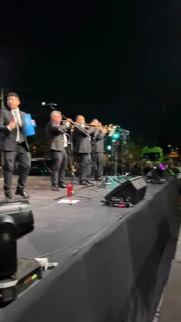 La Banda del Papi tocando de noche sobre un escenario en la calle